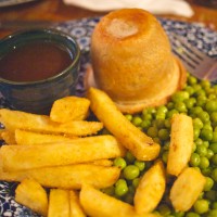 The upper left is gravy. the upper centre thing is the pudding. Yum. Chips below,  Can you guess what the green things are?